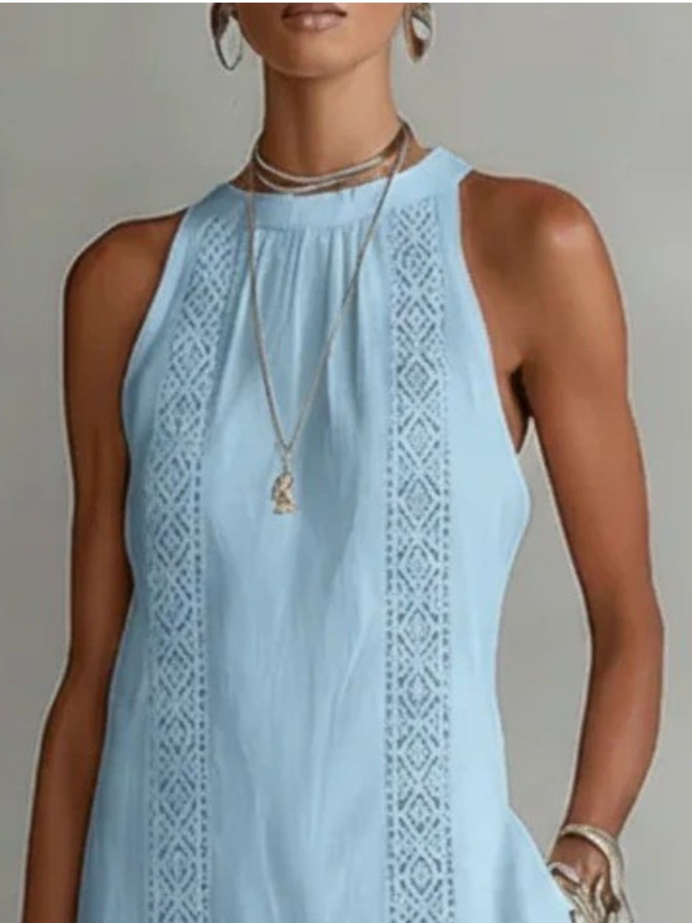 Light blue sleeveless dress with intricate patterns on a neutral background